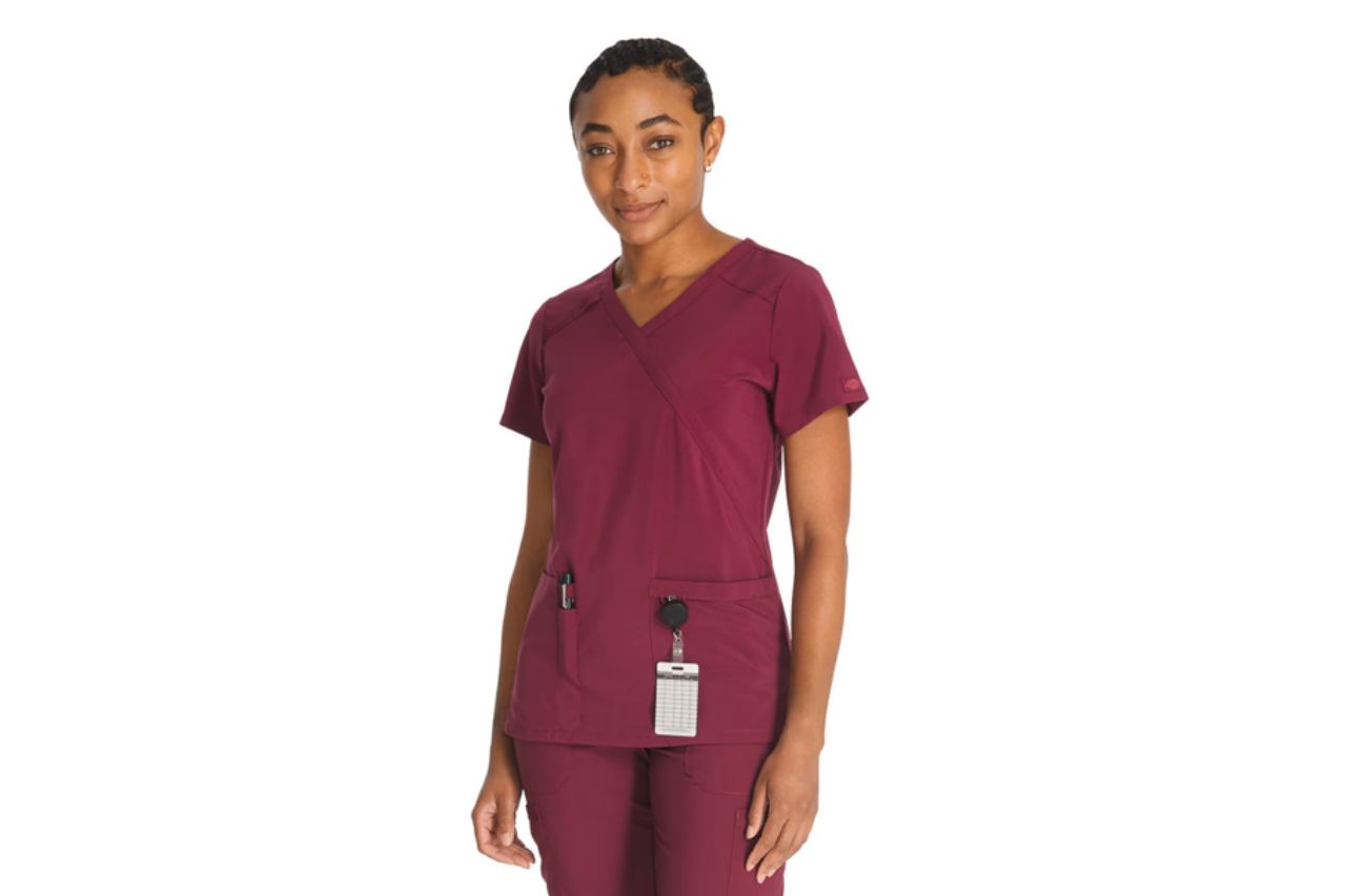 <p>Women's polyester and elastane wrap-around top, offered by Dickies Medical, a brand distributed by TopTex. With a contemporary style, it features instrument loops on the right shoulder, a pen holder with twill tape, a tone-on-tone woven label and a twill tape with exclusive logo inside the collar</p>